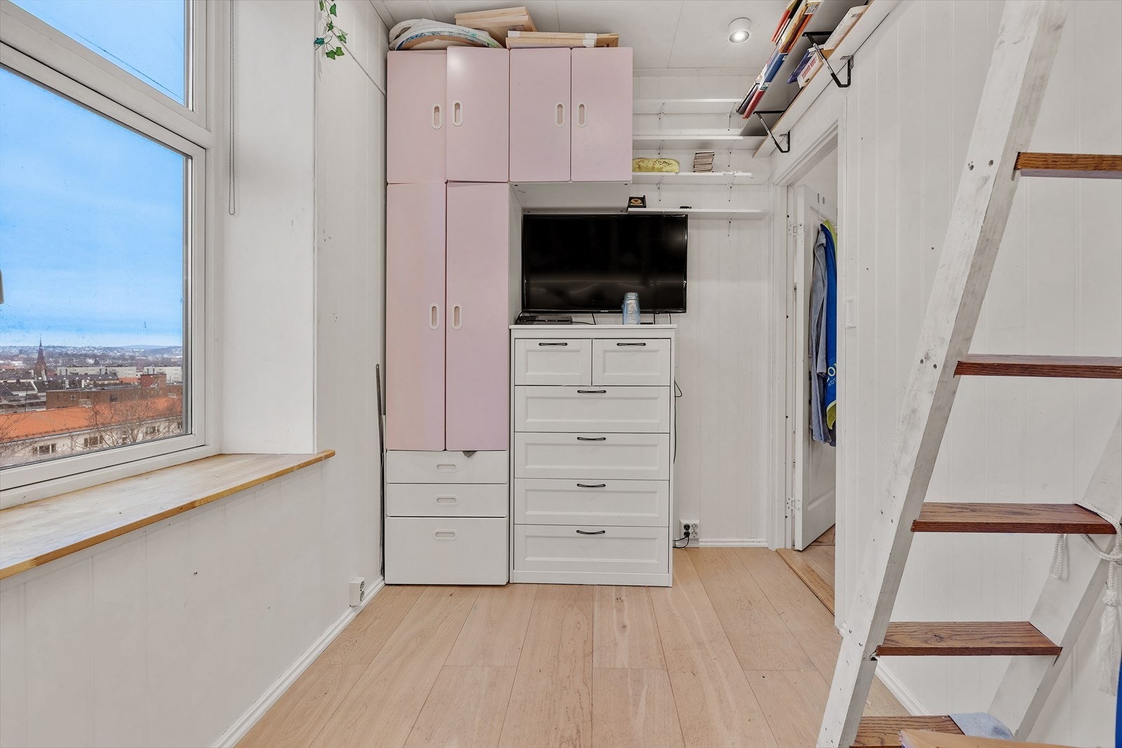 Integrerte skap gir god oppbevaringsplass, og rommet har utsikt mot byen. Galleribilde