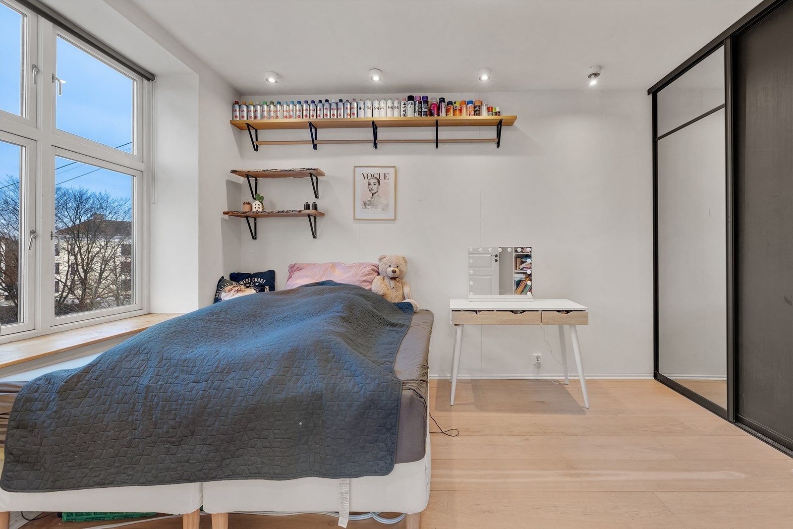 Skyvedørsgarderobe gir effektiv oppbevaring, og store vinduer gir utsyn mot grøntområde. Galleribilde