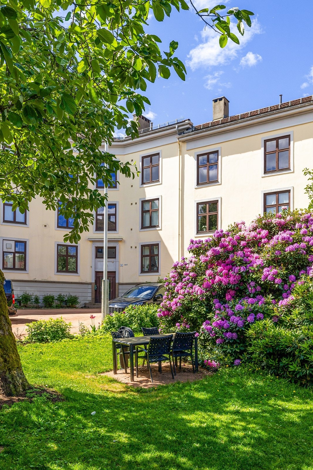 Blomstrende hage og sitteplasser på fellesområdet gir et innbydende uterom. Galleribilde