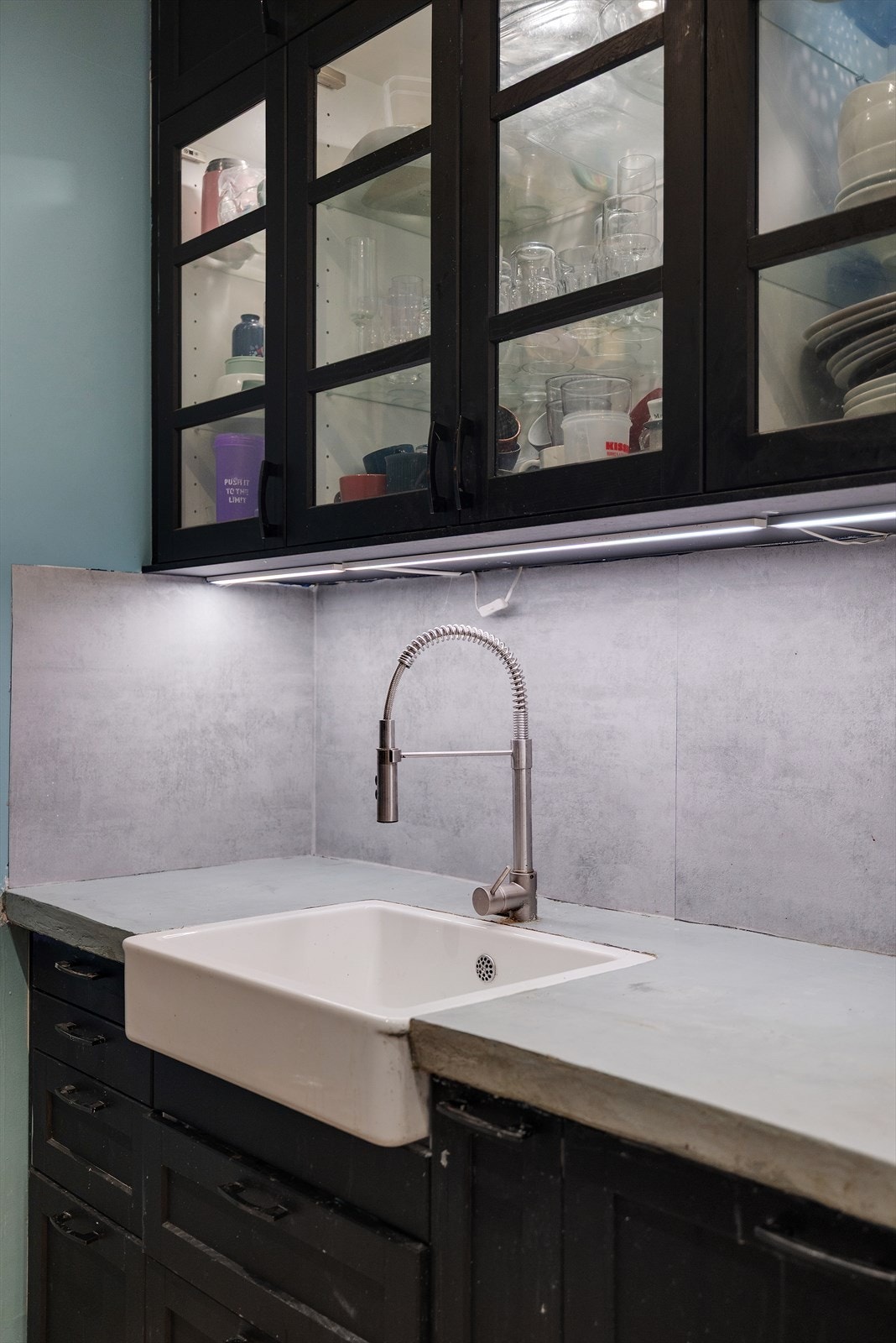 Glassfronter på overskap gir enkel oversikt, mens benkeplaten er belagt med microsement. Galleribilde