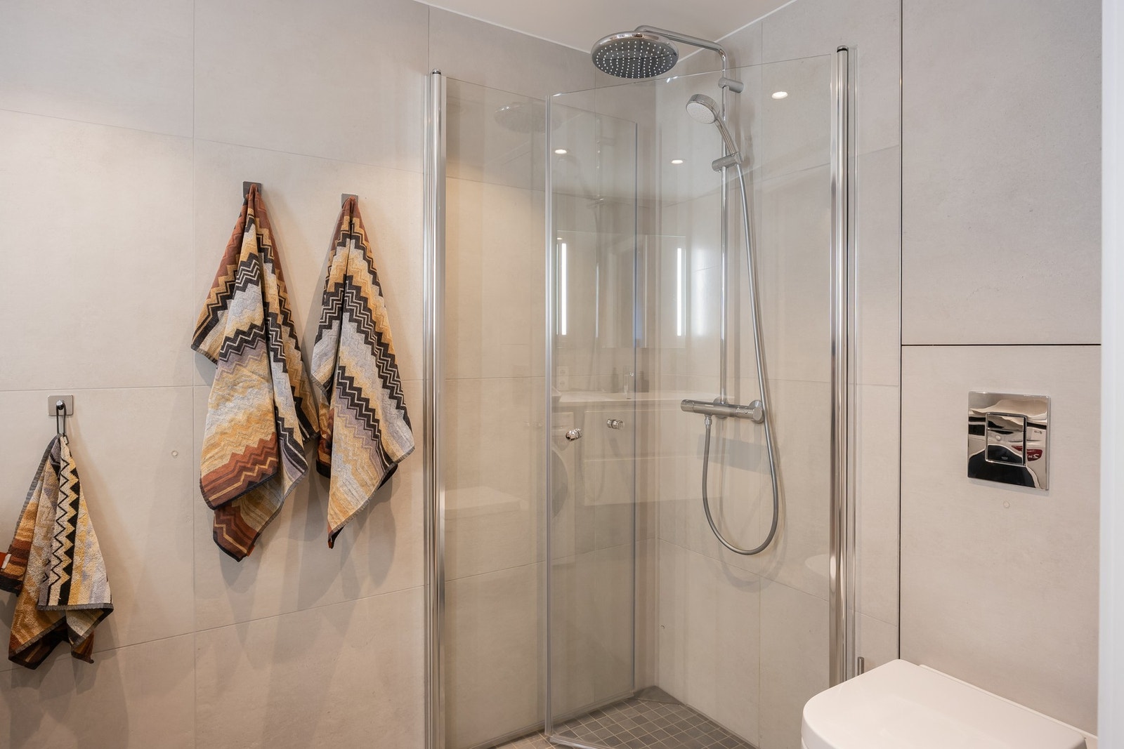 Baderommet har en praktisk utforming og praktisk dusjnisje med innfellbare glassdører. Galleribilde