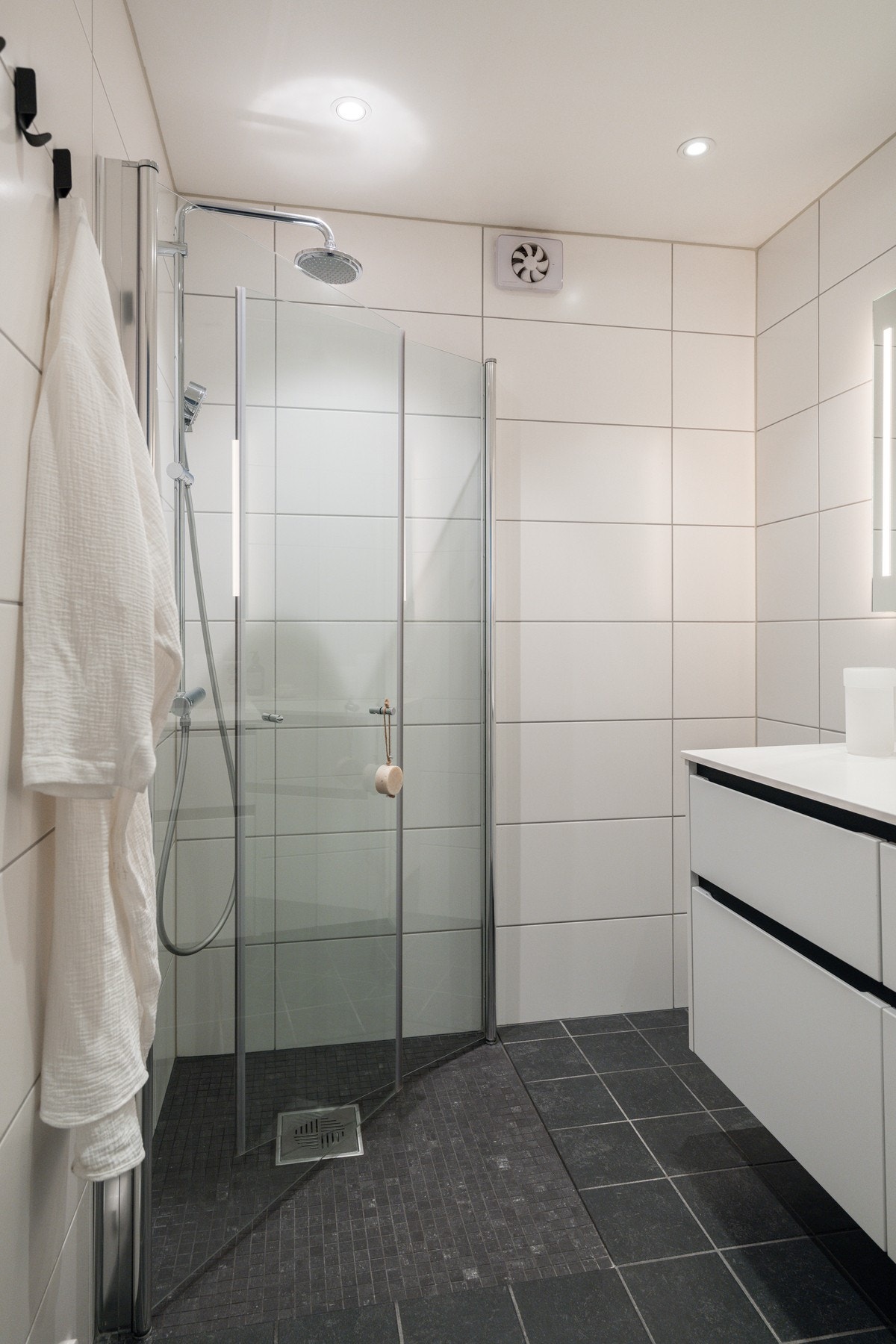 Romslig dusjhjørne med innfellbare dusjvegger. Vegghengt regnfallsdusj samt hånddusj Galleribilde