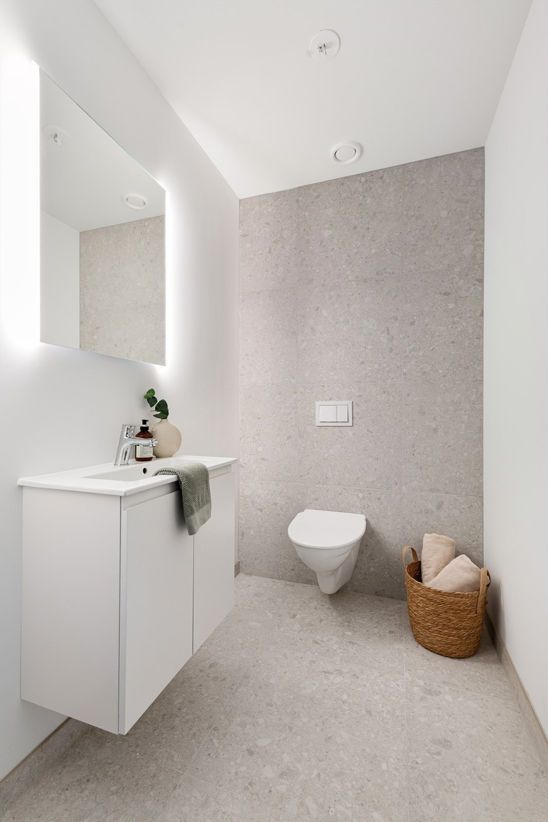 Gjestetoalettet har god størrelse, har innredning med servant og speil. Flislagt gulv og flislagt vegg bak toalett. Galleribilde