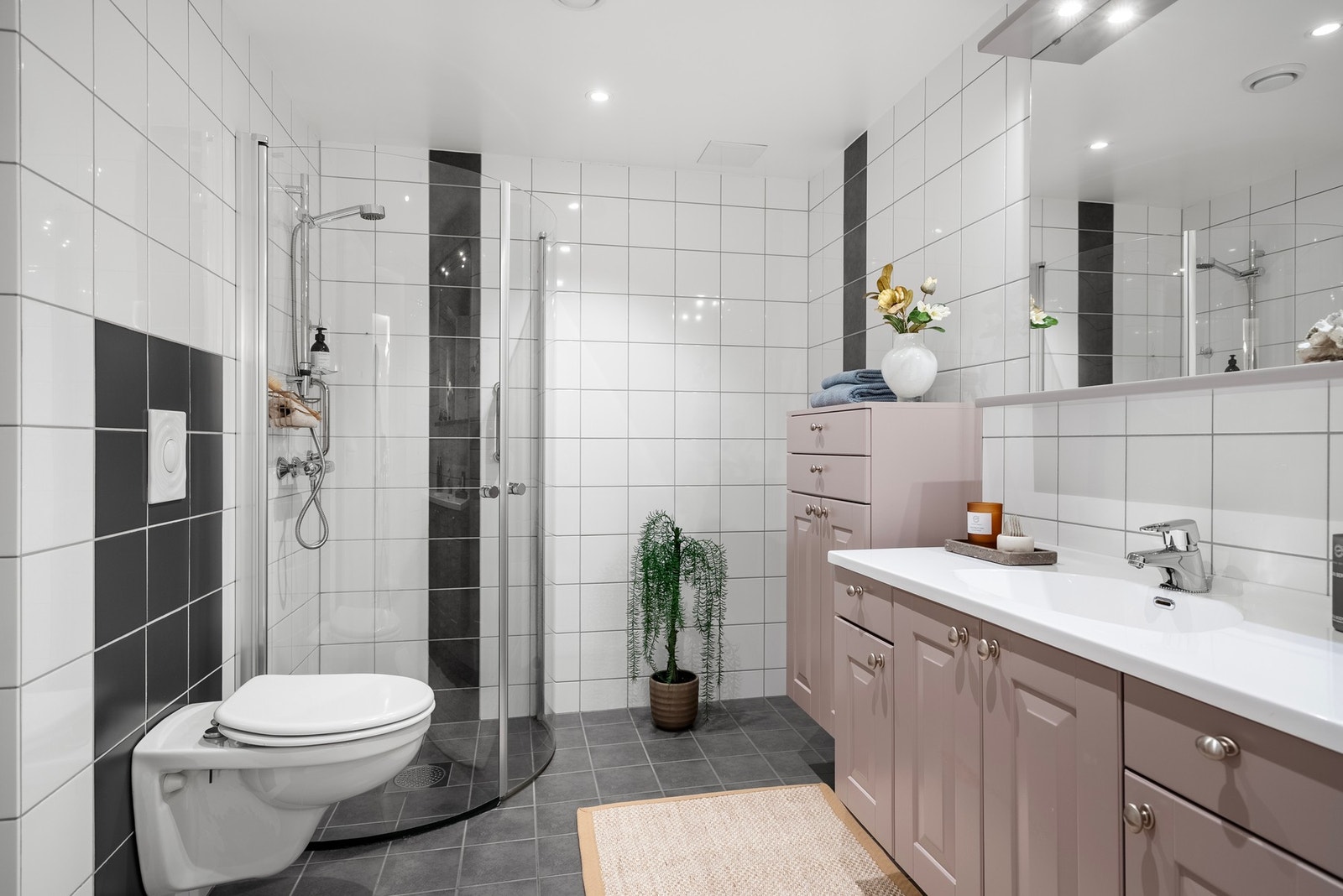 Helfliset bad med varmekabler i gulvet og god oppbevaringsplass i servantinnredning og ekstra skap Galleribilde