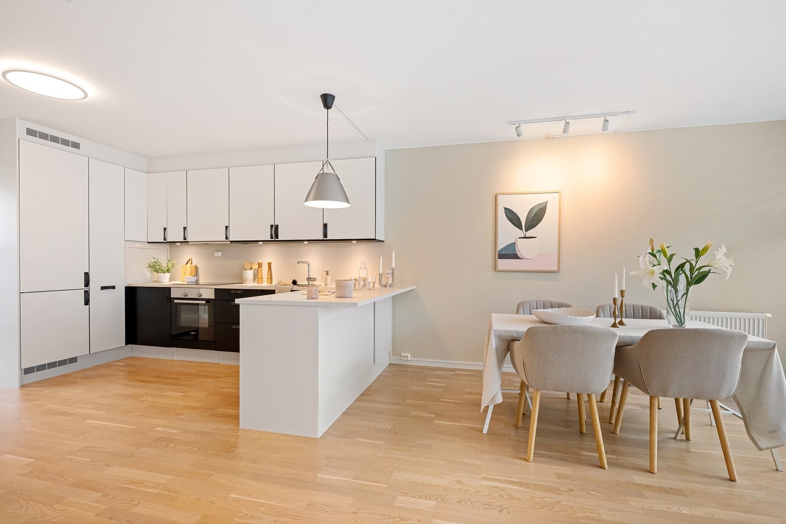 Åpen løsning mellom kjøkken og stue gir en luftig atmosfære Galleribilde