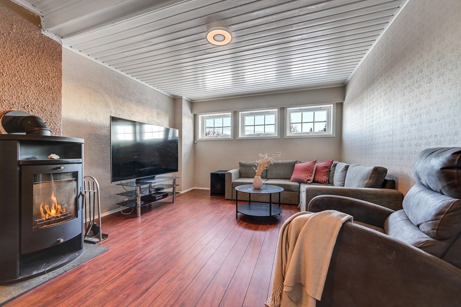 I underetasjen er det en trivelig kjellerstue (ikke godkjent som oppholdsrom) med godt lysinnslipp fra 3 vinduer, samt peis og varmepumpe Galleribilde