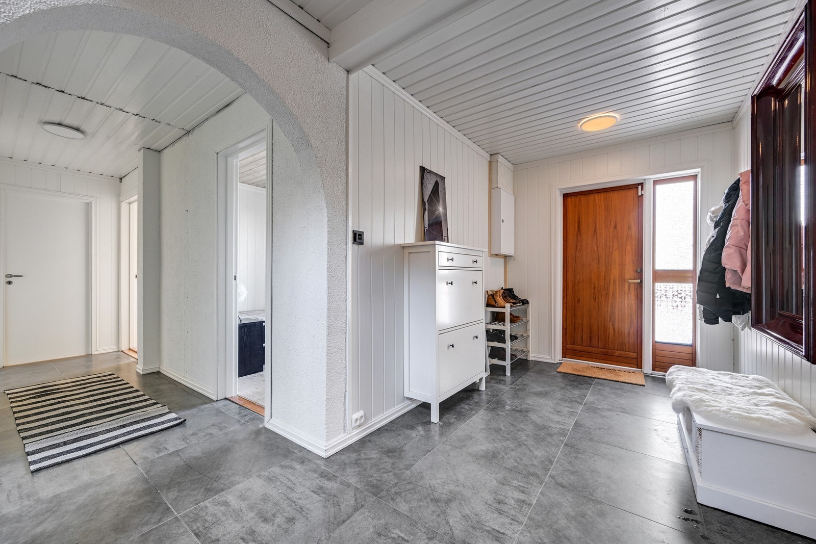 Velkommen inn i entréen med en lekker flis av gråtoner på gulvet. Det er god plass til å organisere både sko og klær Galleribilde