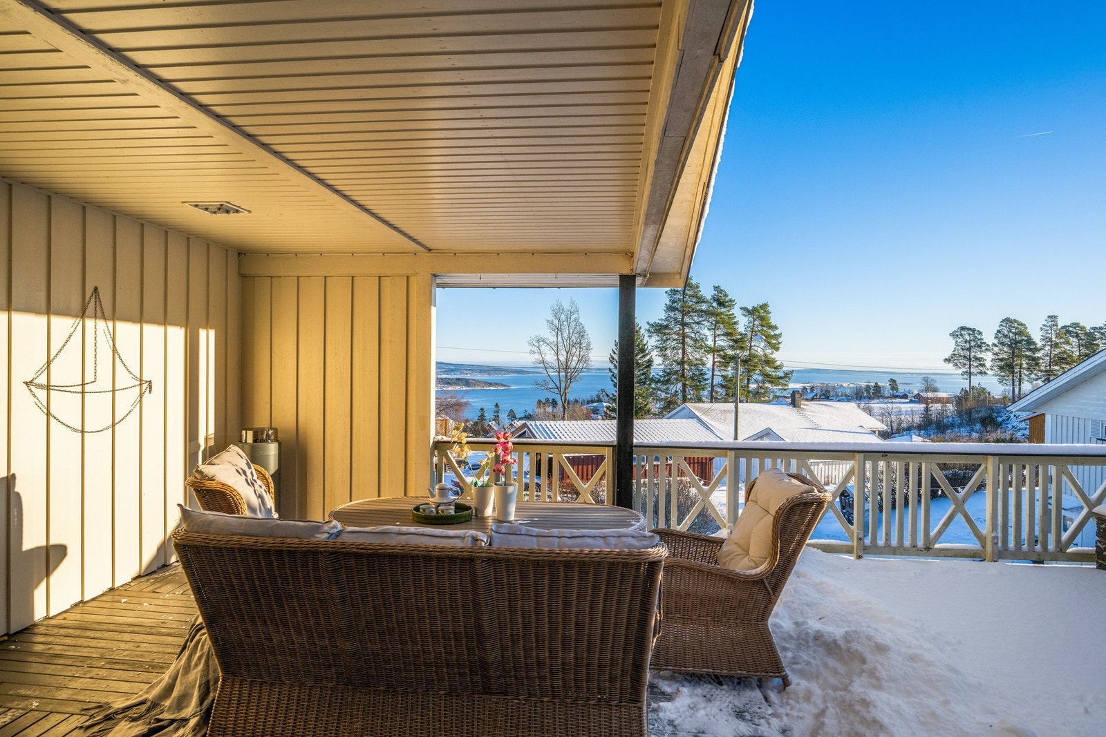 Utgang fra stuen til en delvis takoverbygd terrasse. Herfra kan man nyte flott utsikt mot sjøen Galleribilde