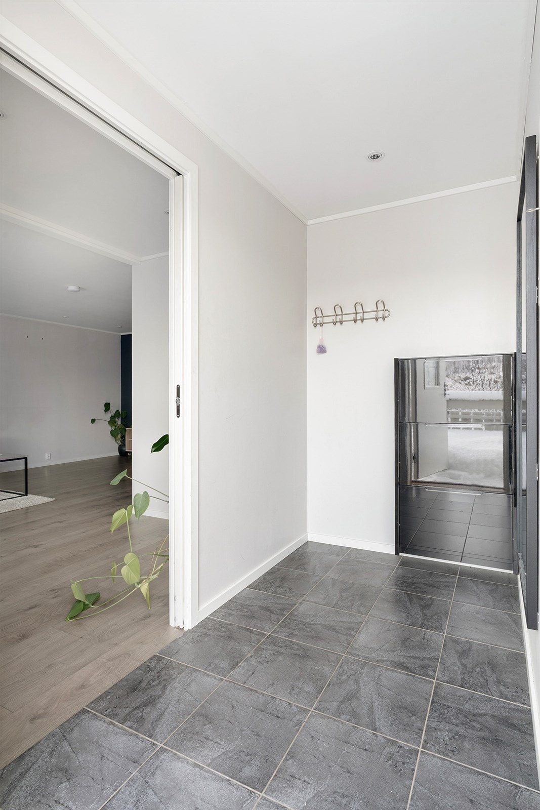 Gang med varme i gulv, og plassbesparende skyvedør inn til stua Galleribilde