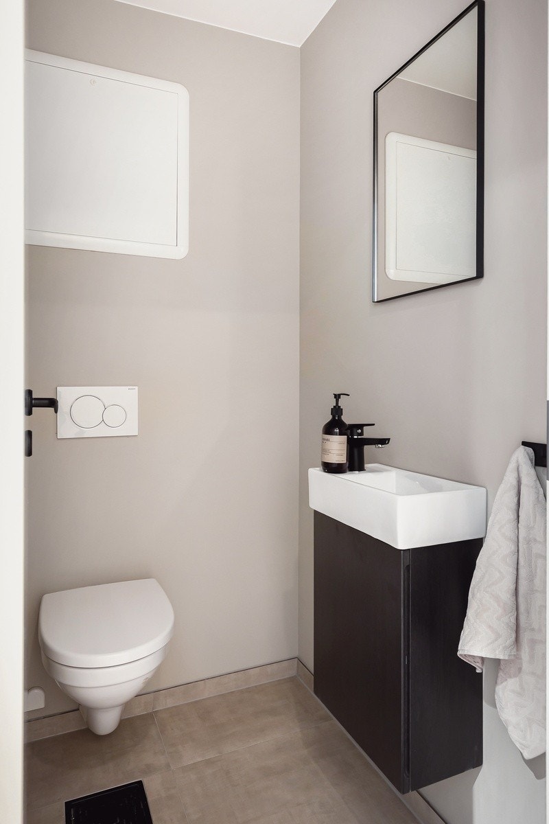 Praktisk ekstra toalettrom med flis på gulv og høy standard. Toalett og servant. Galleribilde