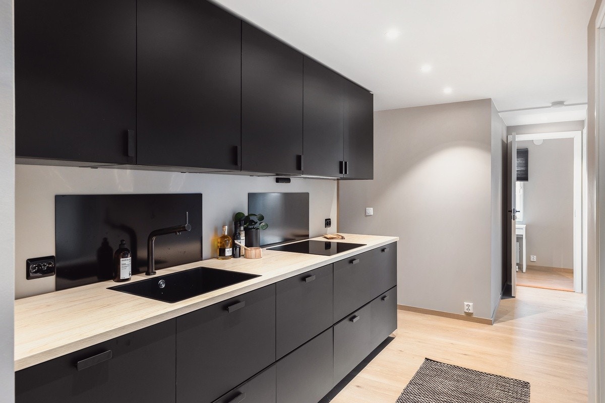 Råstilig kjøkken med integrerte hvitevarer og alt av kjøkkentilbehør. Spotter i tak. Galleribilde