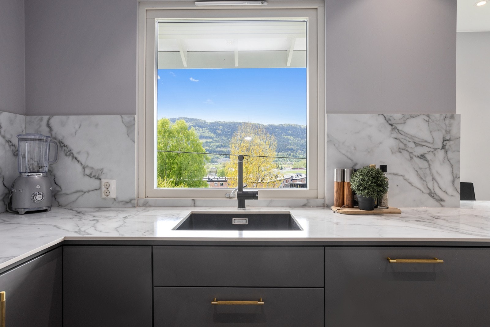 Underlimt vask med sort kran. Det er hyggelig å ta oppvasken til utsikt Galleribilde