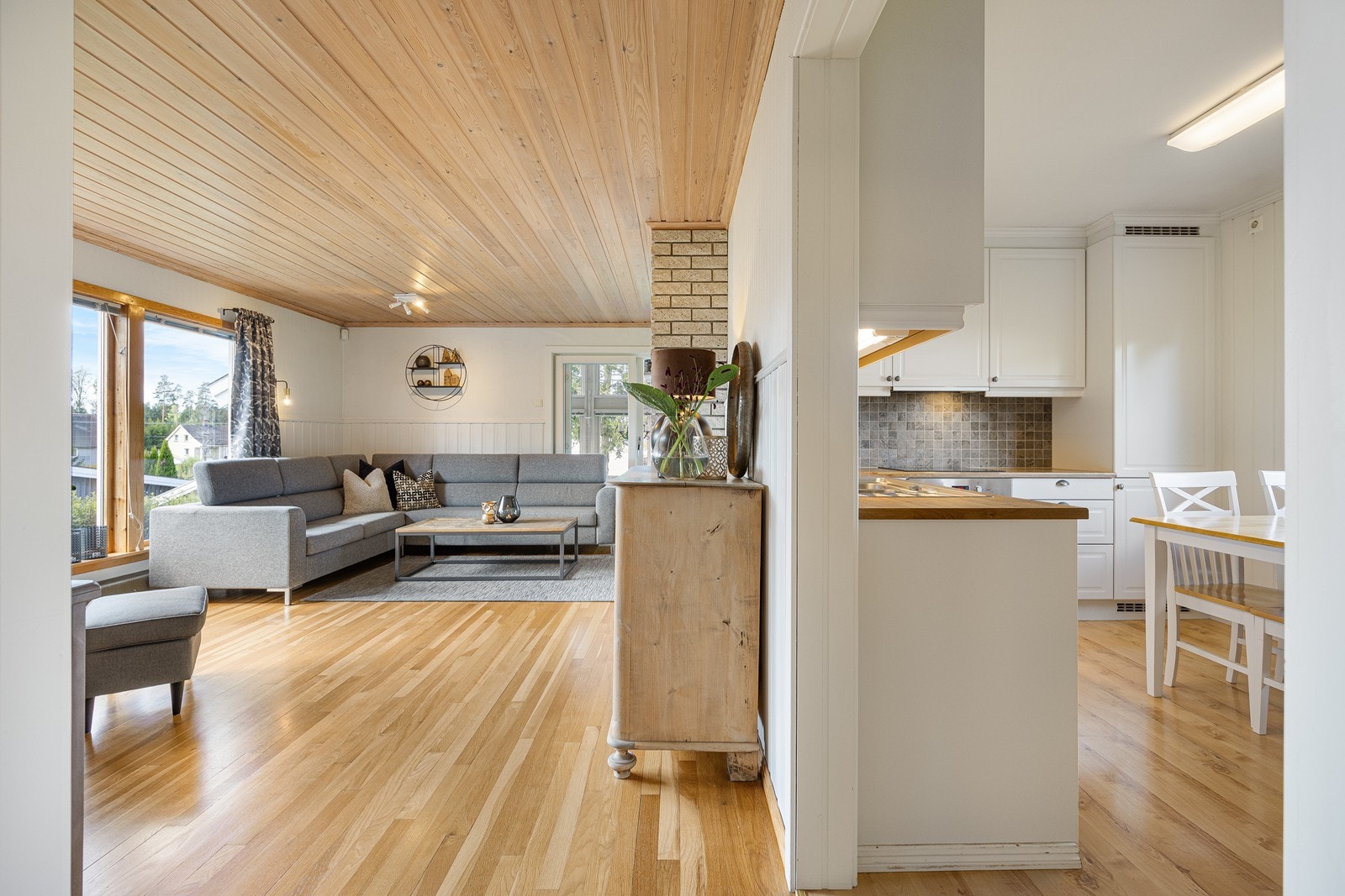 Gangen glir sømløst over i kjøkken og stue - med det samme gyldne, enstavs laminatgulvet. Galleribilde