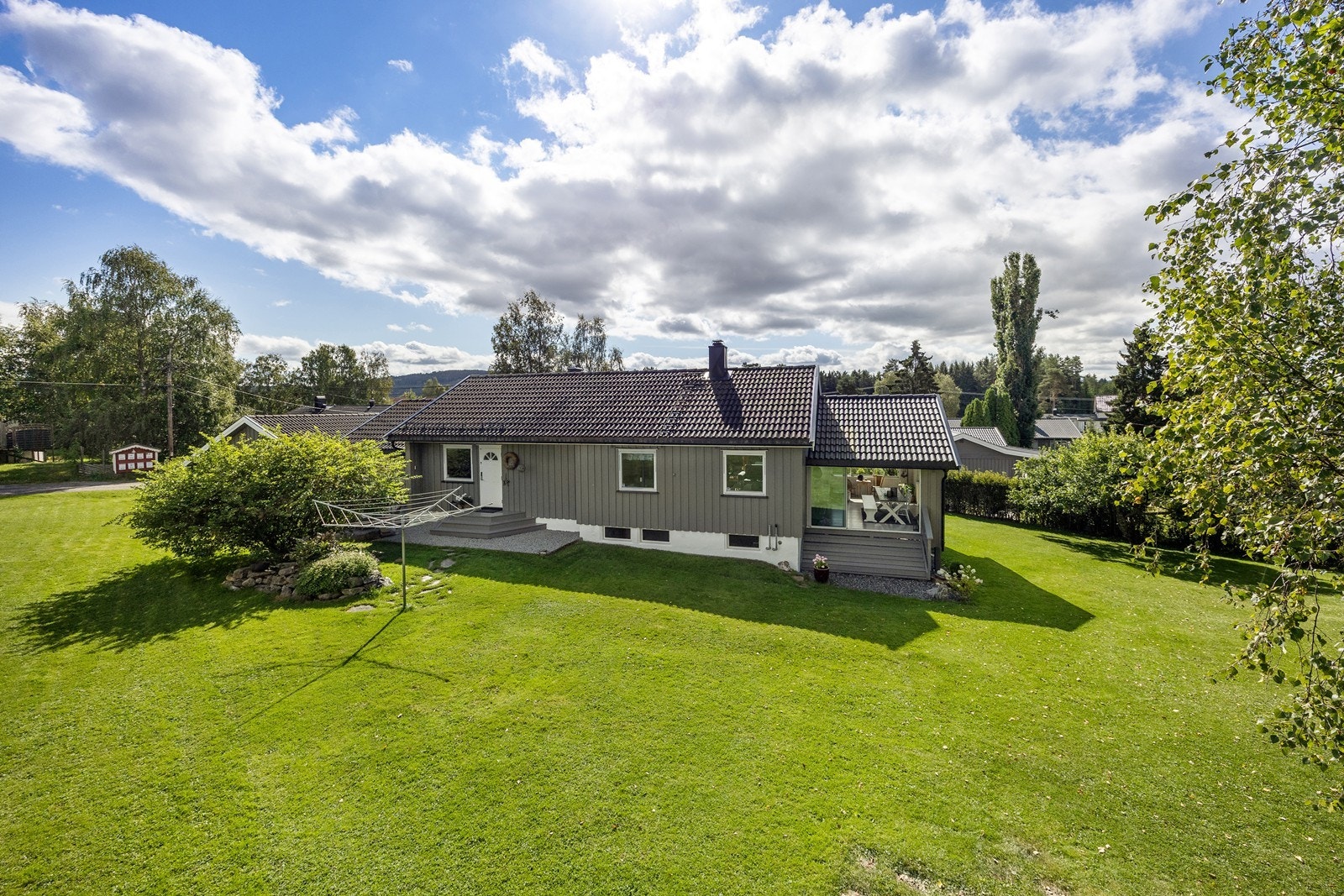 Tomten er pent opparbeidet med plenareal, frukttrær, prydbusker og diverse beplantning. Galleribilde