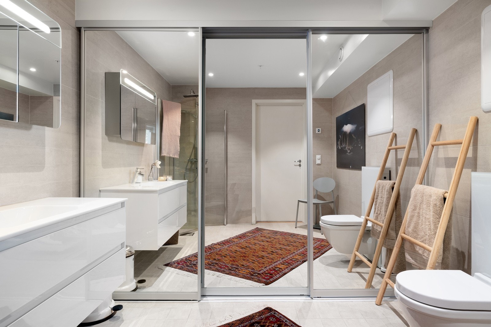 Flislagt bad med gulvvarme og praktiske løsninger som vegghengt toalett og skyvedører som skjuler vaskemaskin og tørketrommel! Galleribilde