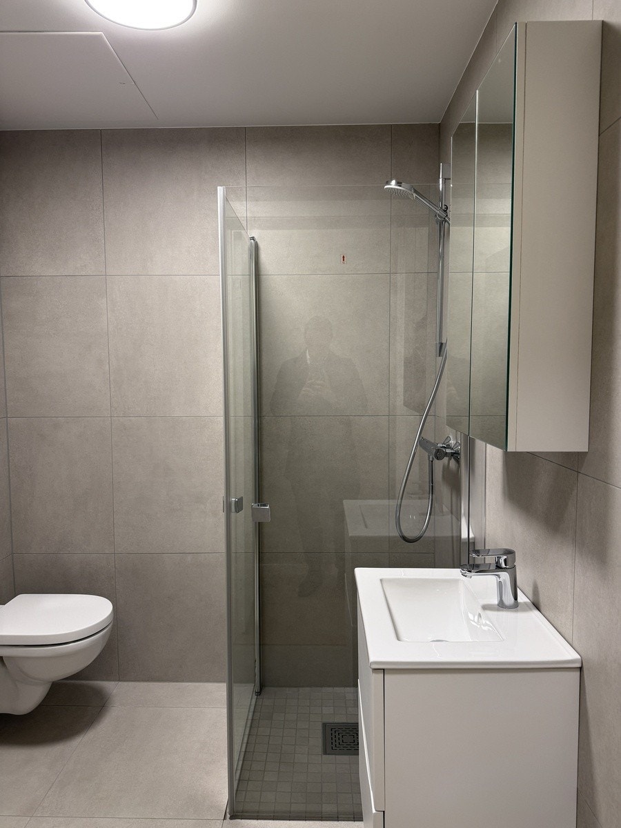 fliselagt bad med varmekabler og opplegg for vaskemaskin Galleribilde