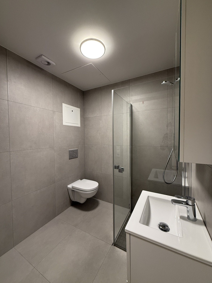 fliselagt bad med varmekabler og opplegg for vaskemaskin Galleribilde