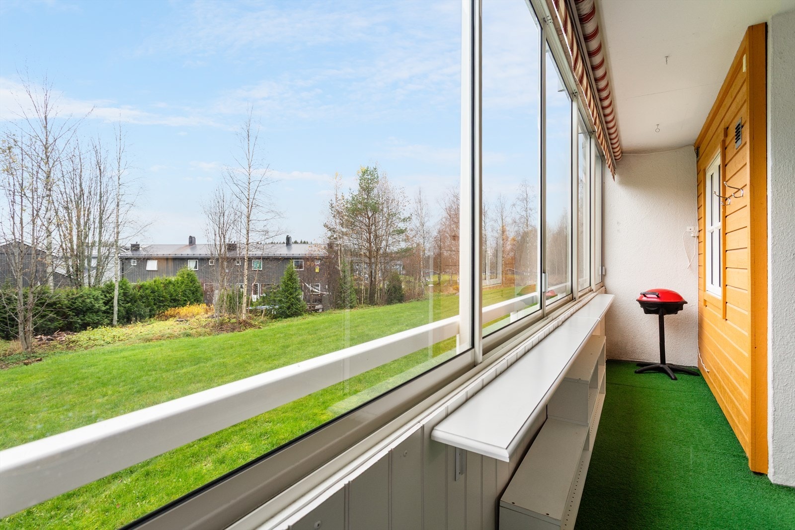 Grøntarealer og område med trær mellom leiligheten og neste nabo Galleribilde