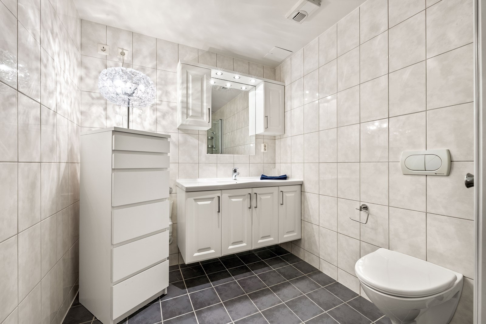 Innredningen består av servant, vegghengt toalett, dusjhjørne og opplegg for vaskemaskin. Galleribilde