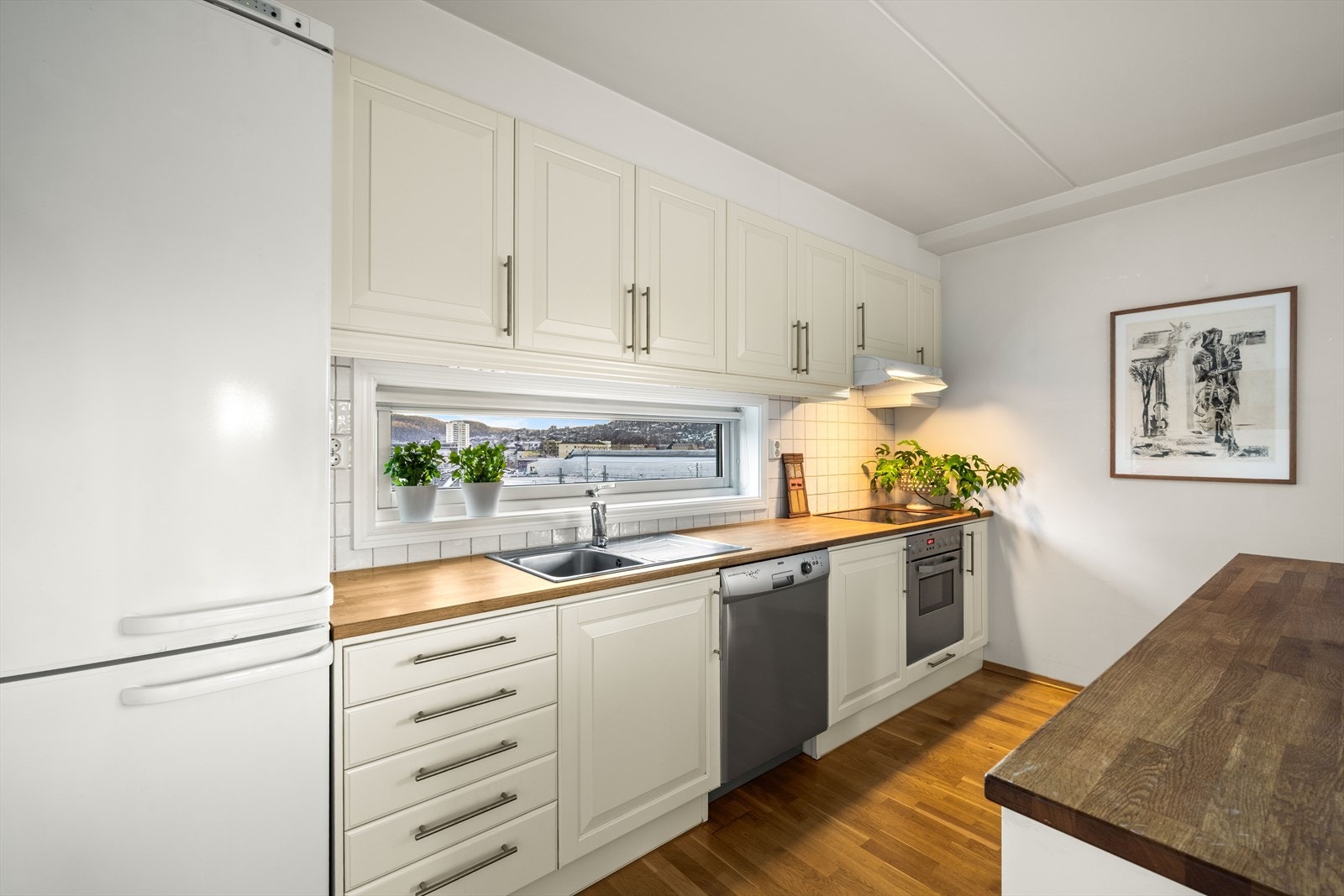 En solid benkeplate i heltre gir en varm kontrast til de lyse frontene. Galleribilde