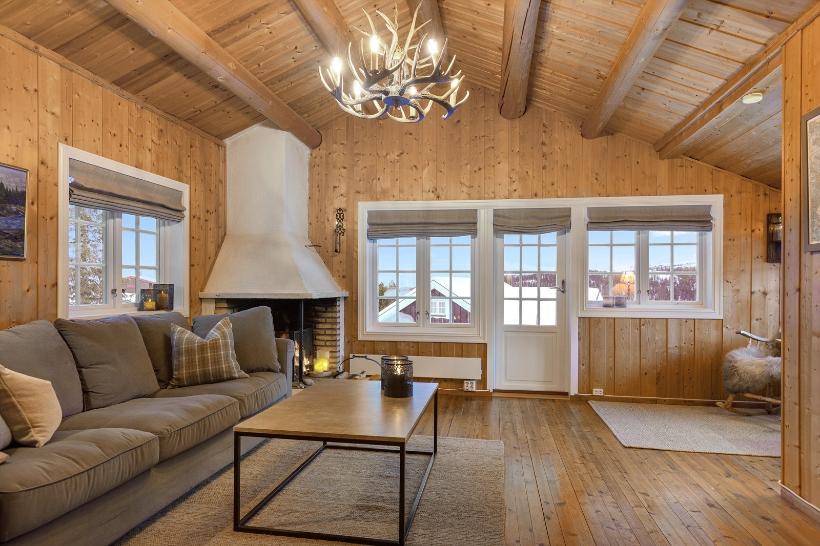 Innvendig er det lun, lys og innbydende stue med mønet himling og synlige tømmeråser. Galleribilde