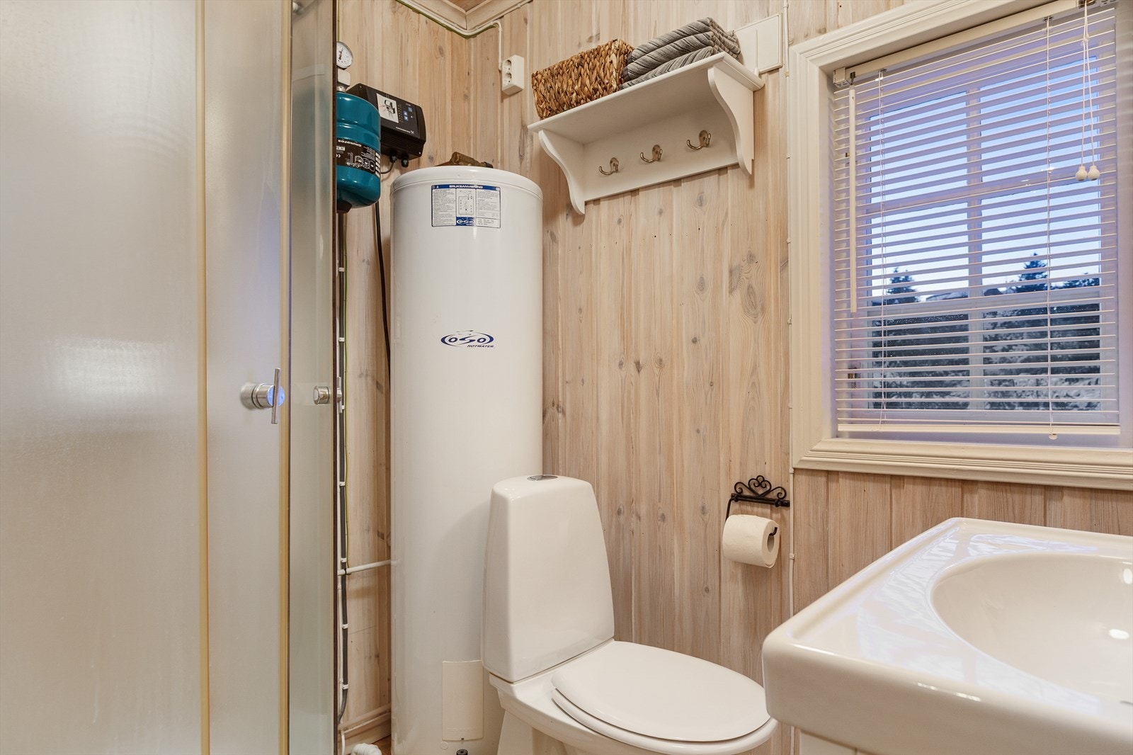 Badet har et rustikt uttrykk med tregulv og trepanel på vegger og himling. Her finner du servantskap, speilskap, toalett, dusjkabinett samt tekniske installasjoner. Galleribilde