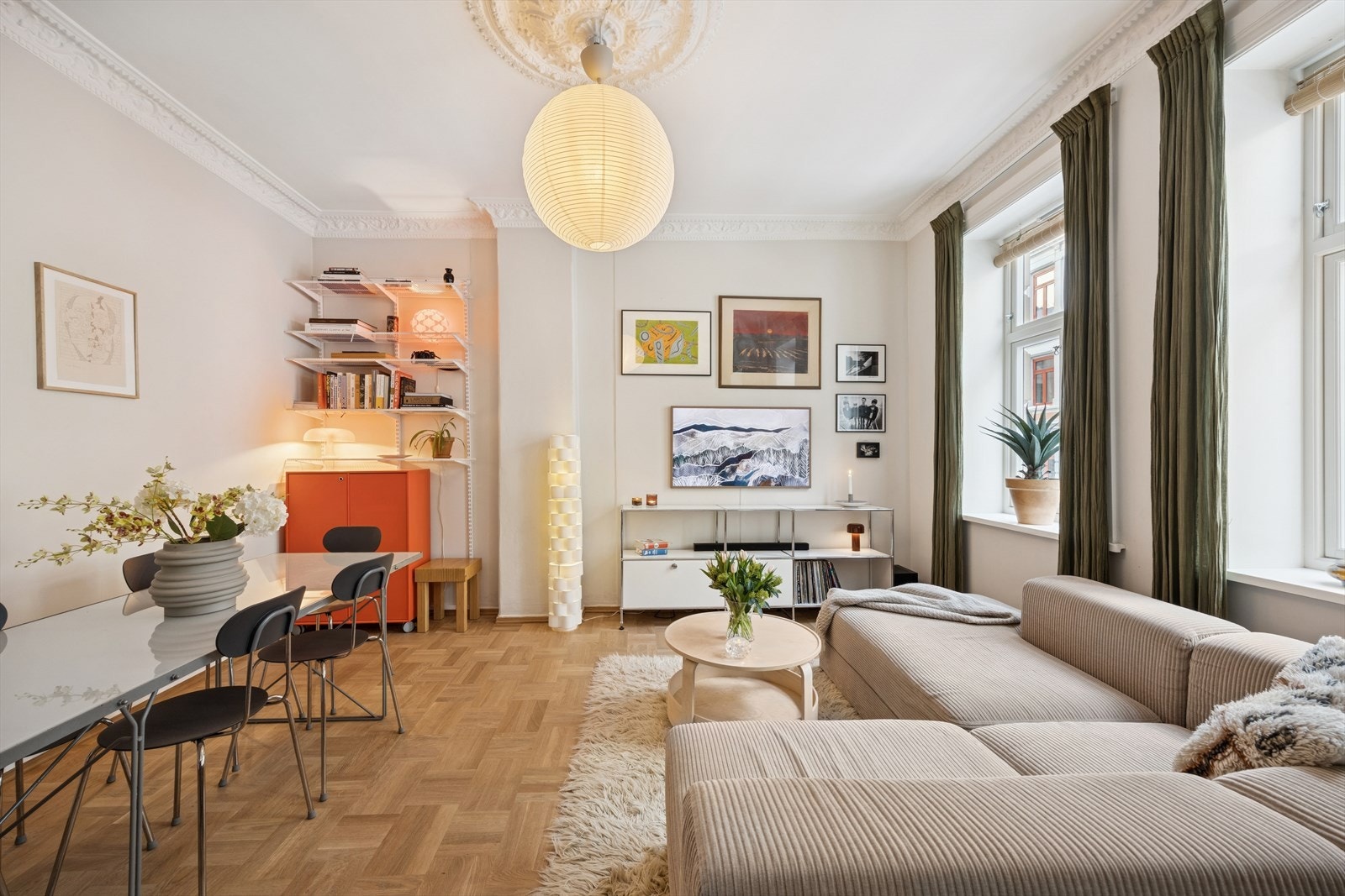 Stilren stue hvor et moderne uttrykk møter klassiske detaljer, og naturlig lys som gir leiligheten en behagelig helhet. Galleribilde