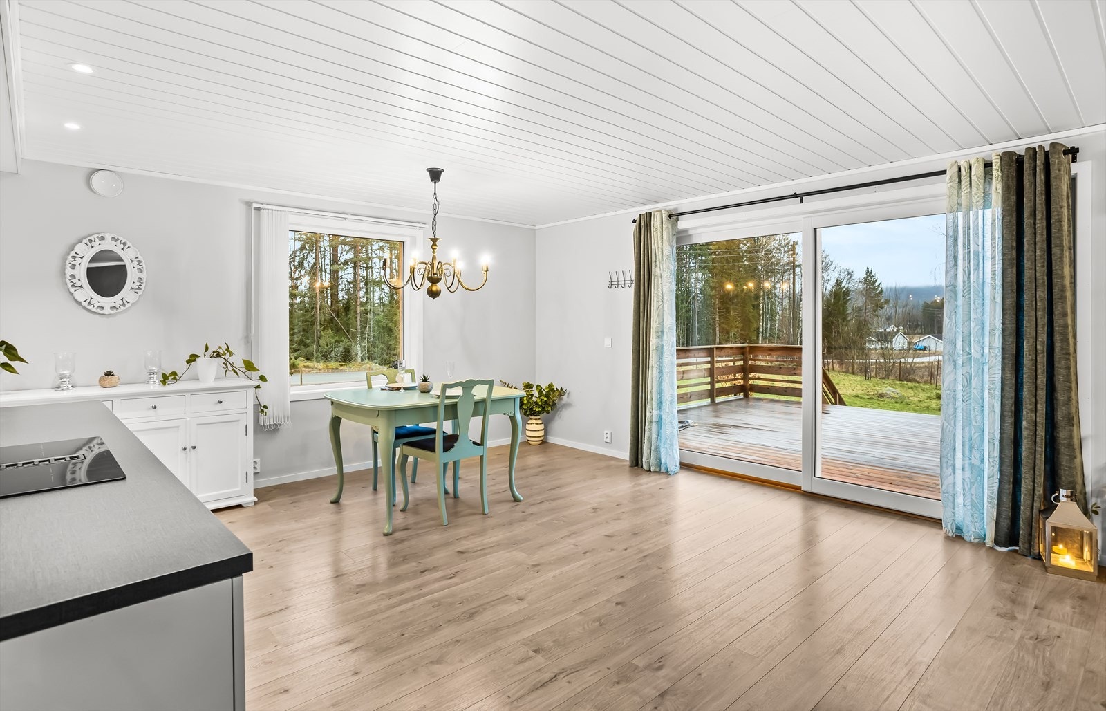 Store skyvedører i glass visker ut skillet mellom inne og ute. Galleribilde