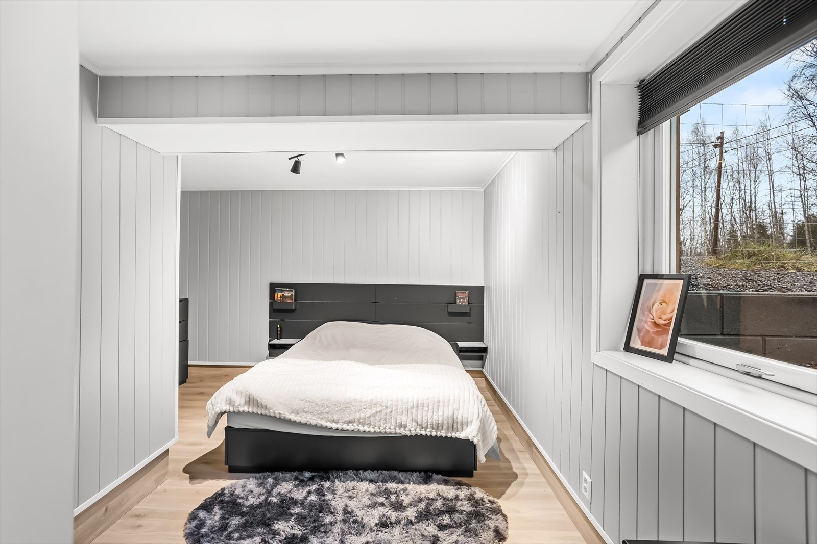 Et av soverommene i underetasjen, med panel på veggene. Galleribilde