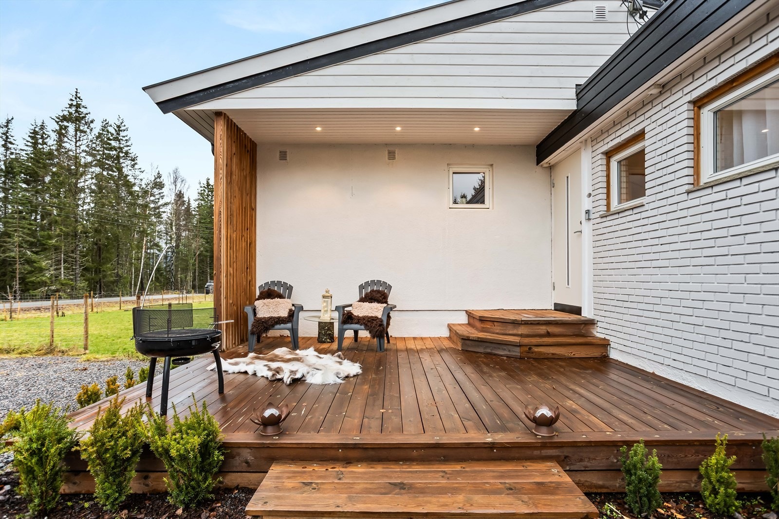 Overbygget uteplass ved inngangspartiet gir ly for vær og vind. Galleribilde