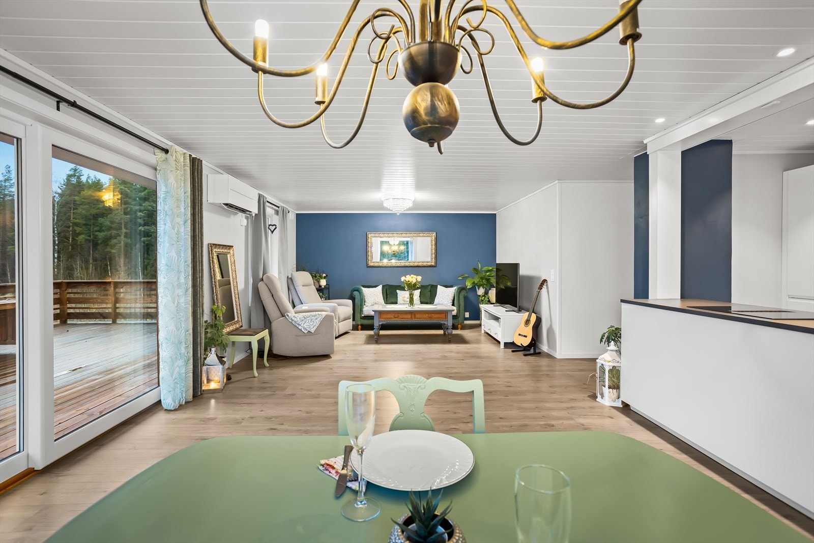 Oversikt over spiseplassen og stuen sett fra kjøkkenet. Galleribilde