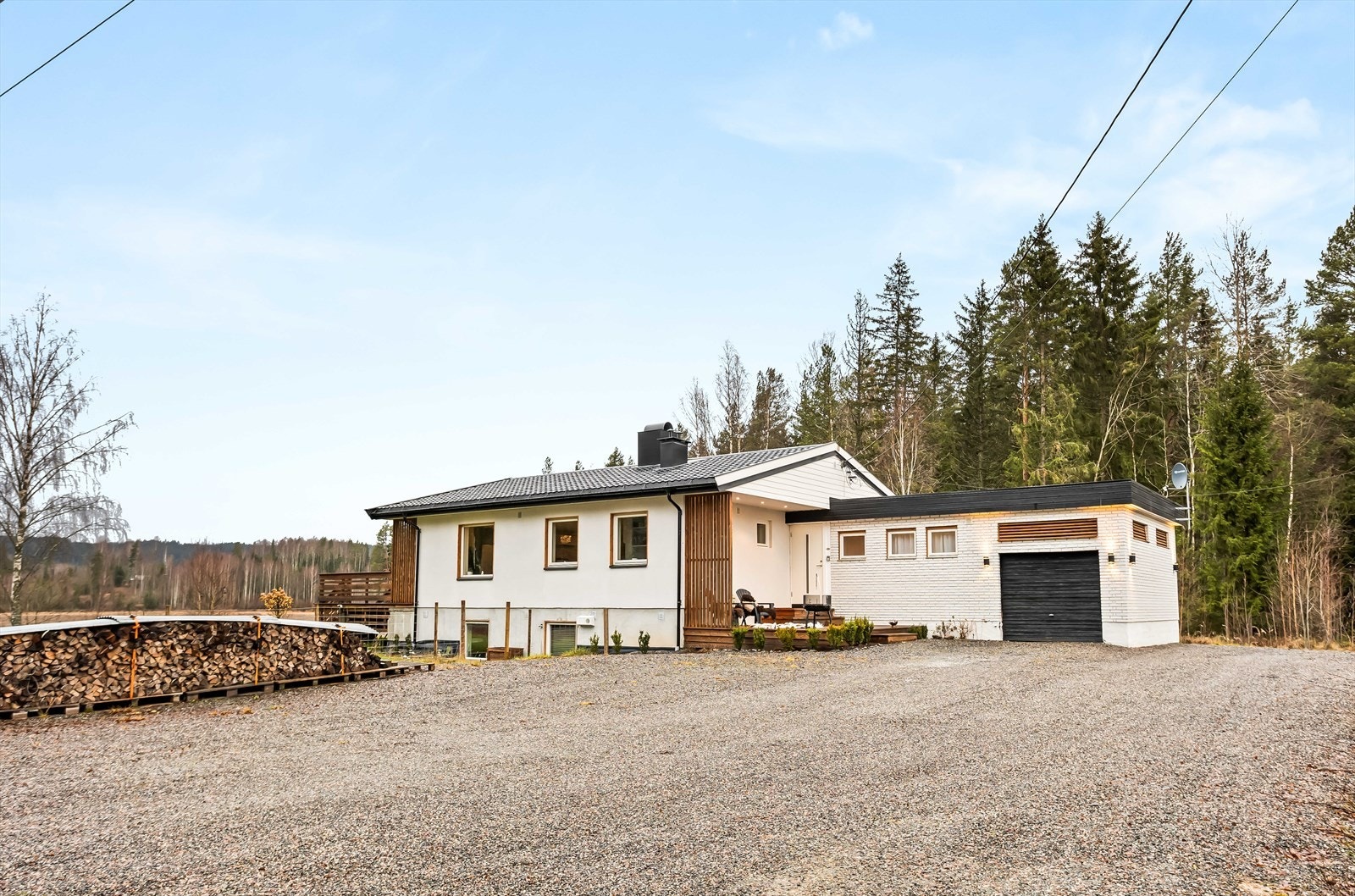 Fasaden er kledd med en kombinasjon av hvitmalt tegl og trepanel. Galleribilde