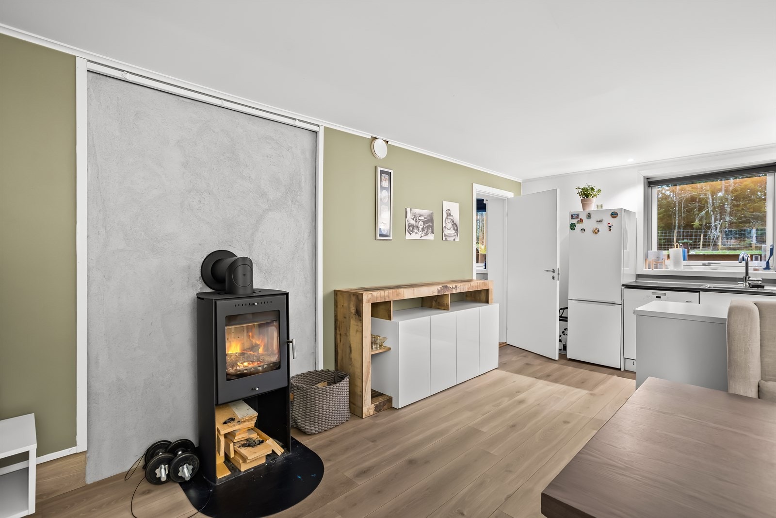 En moderne vedovn i stuen gir en lun og god varme. Galleribilde