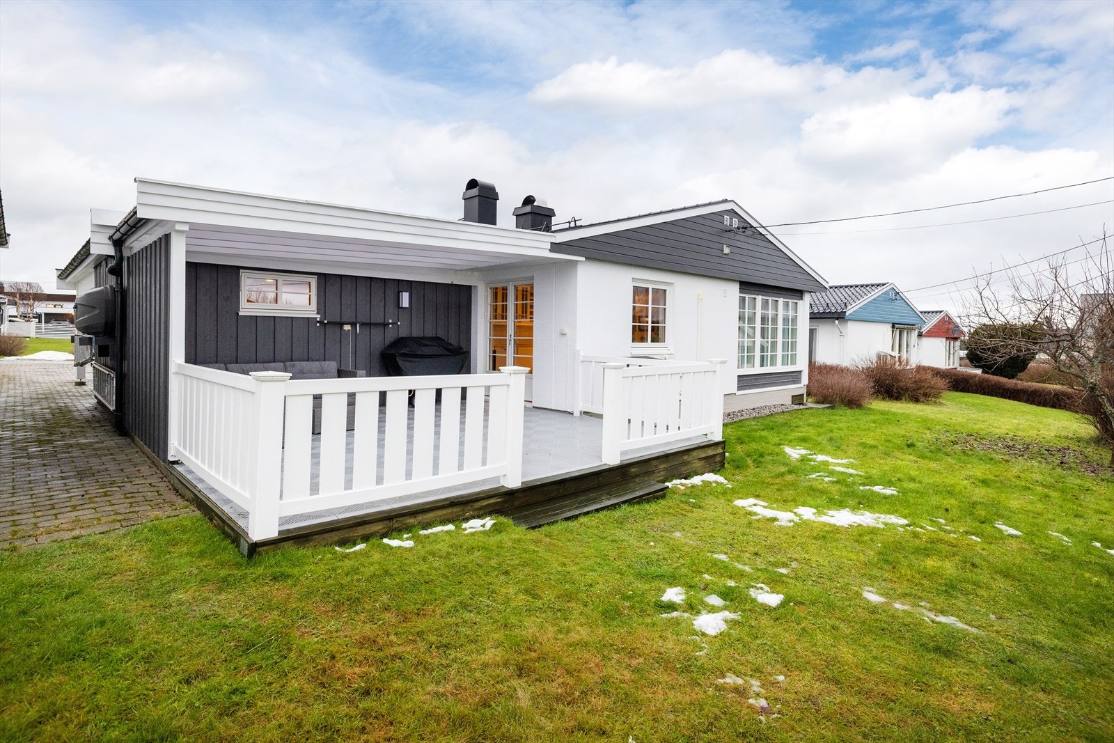 Gårdsplass med belegningsstein forøvrig plen og beplantning Galleribilde