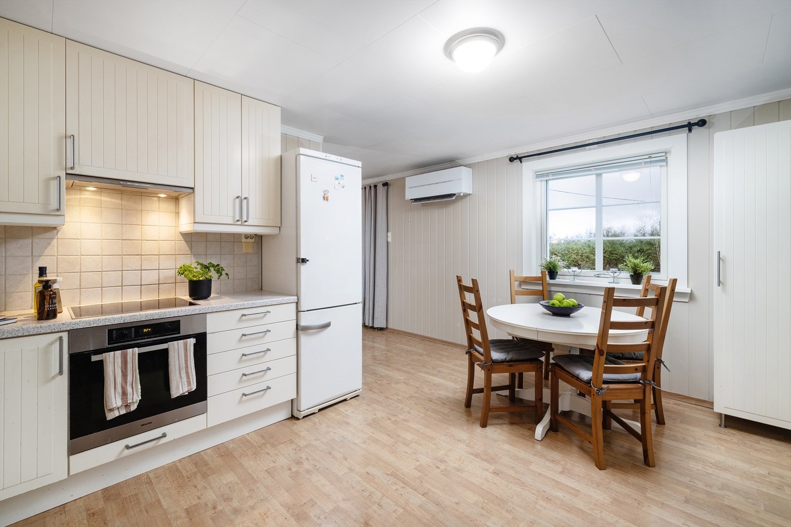 Kjøkkenet har innholdsrik innredning og hyggelig spiseplass Galleribilde