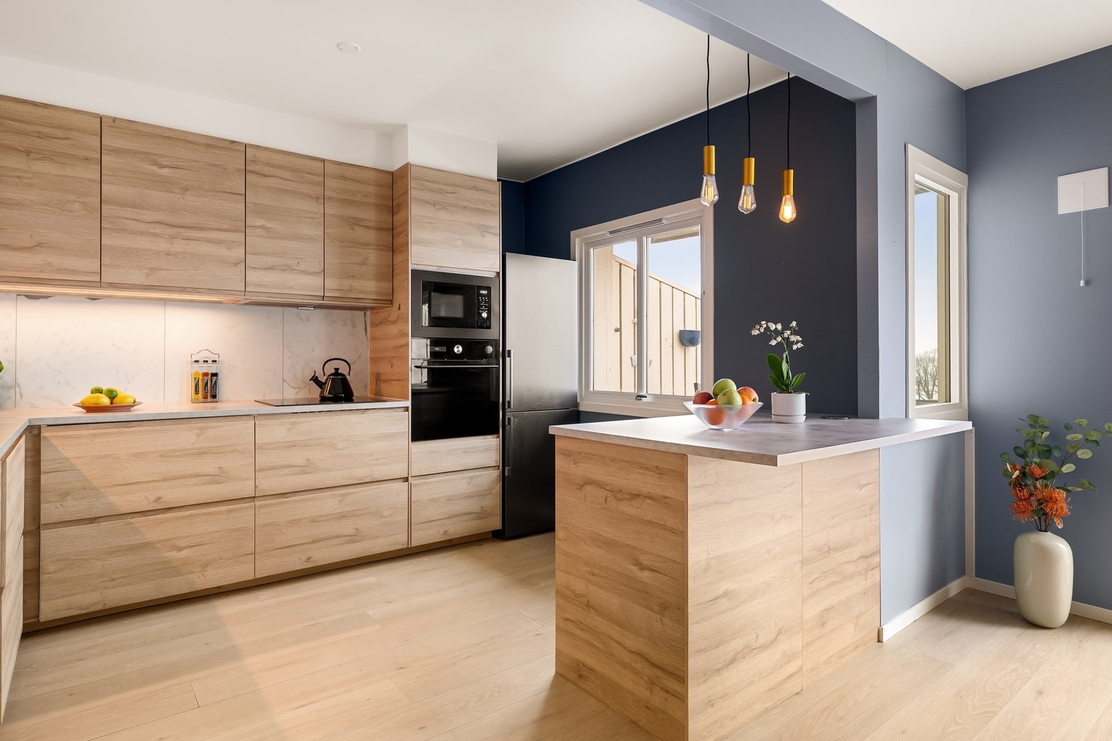 Kjøkkenet har delvis integrerte hvitevarer og godt med skap- og benkeplass Galleribilde