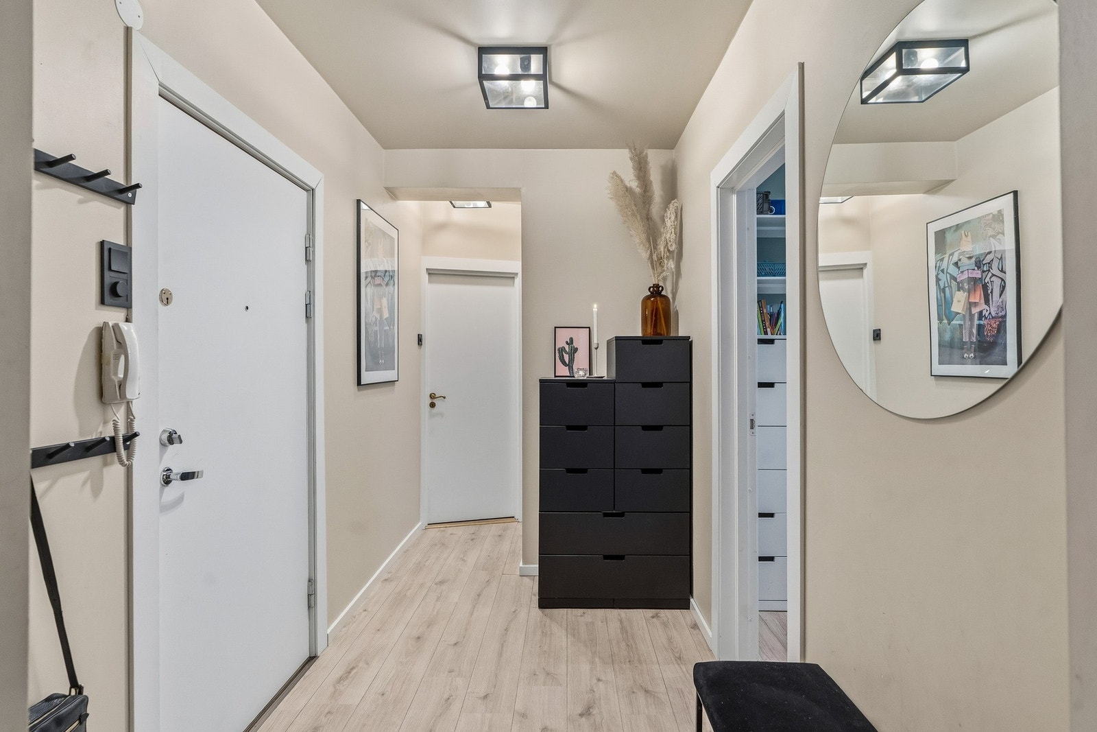 Innbydende entré med plass til yttertøy, kommode og en liten benk. Dørtelefon. Galleribilde