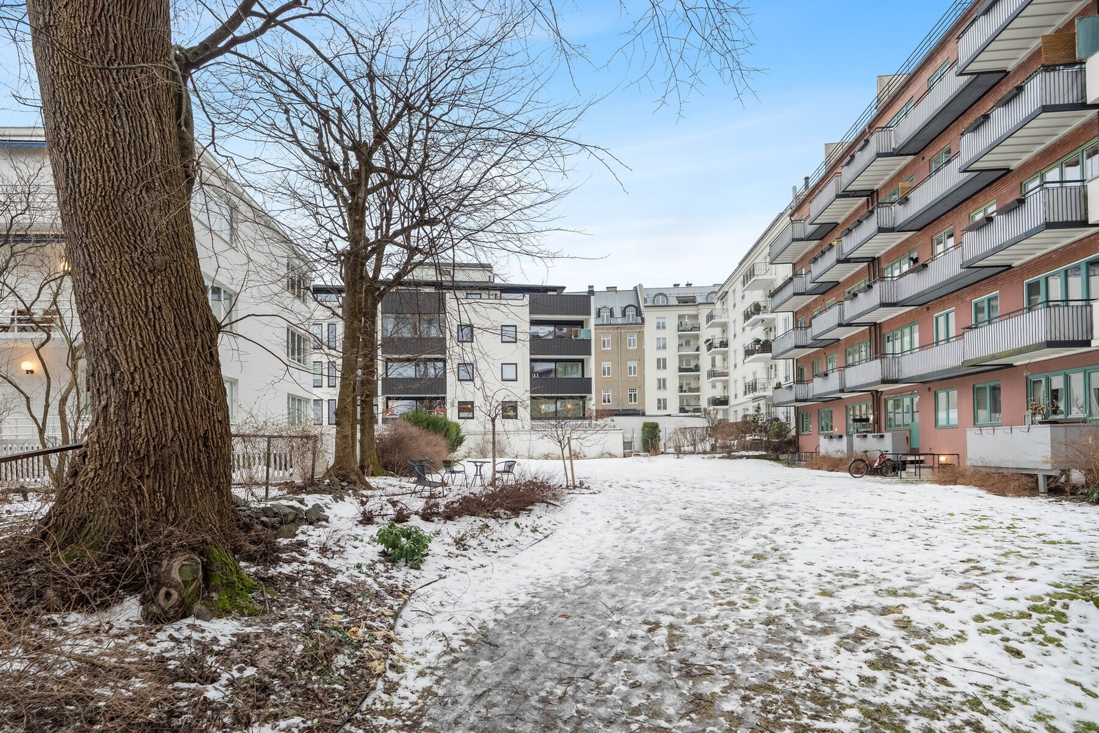 Hyggelig bakhage med plen, sittegruppe og beplantning for beboerne sommerstid. Galleribilde