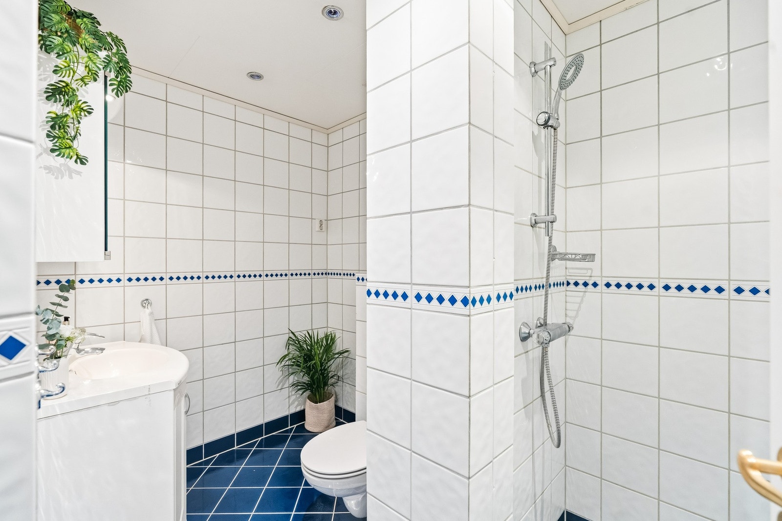 Praktisk utformet baderom fra ca. år 2002. Badet består av vegghengt toalett, servant med underskap, dusjhjørne samt opplegg for vaskemaskin. Varmekabler i gulv. Galleribilde