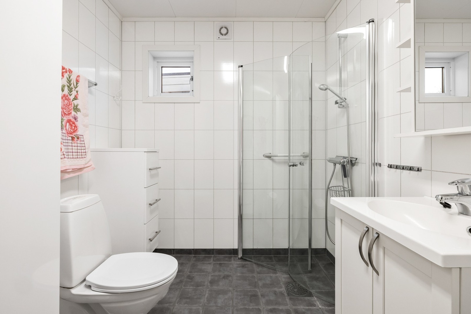 Badet har vegger med våtromsplater og flislagt gulv, som gir et moderne og lettstelt uttrykk Galleribilde