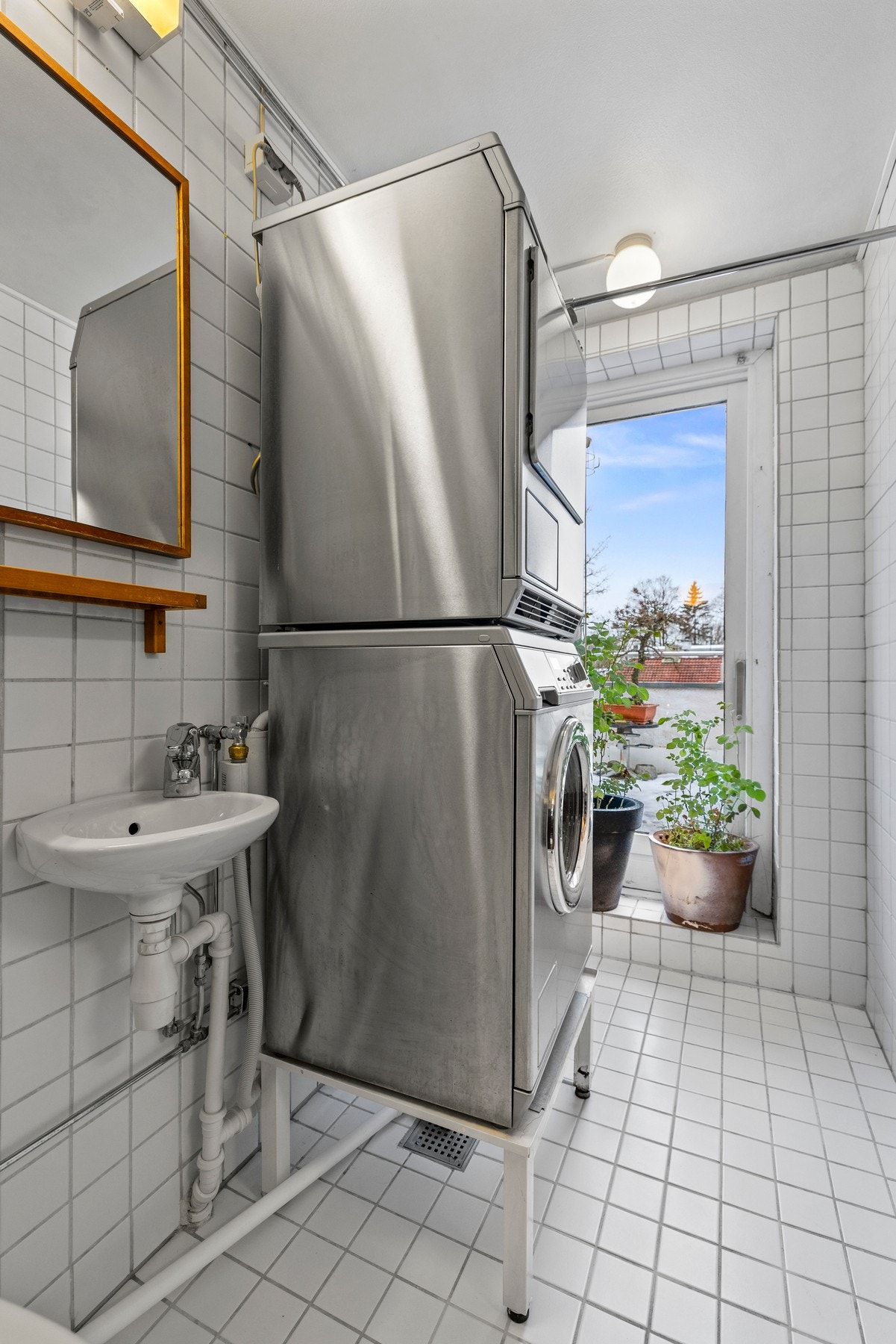 Det er innredet med servant, gulvstående toalett, dusjhjørne med vegger og opplegg for vaskemaskin Galleribilde