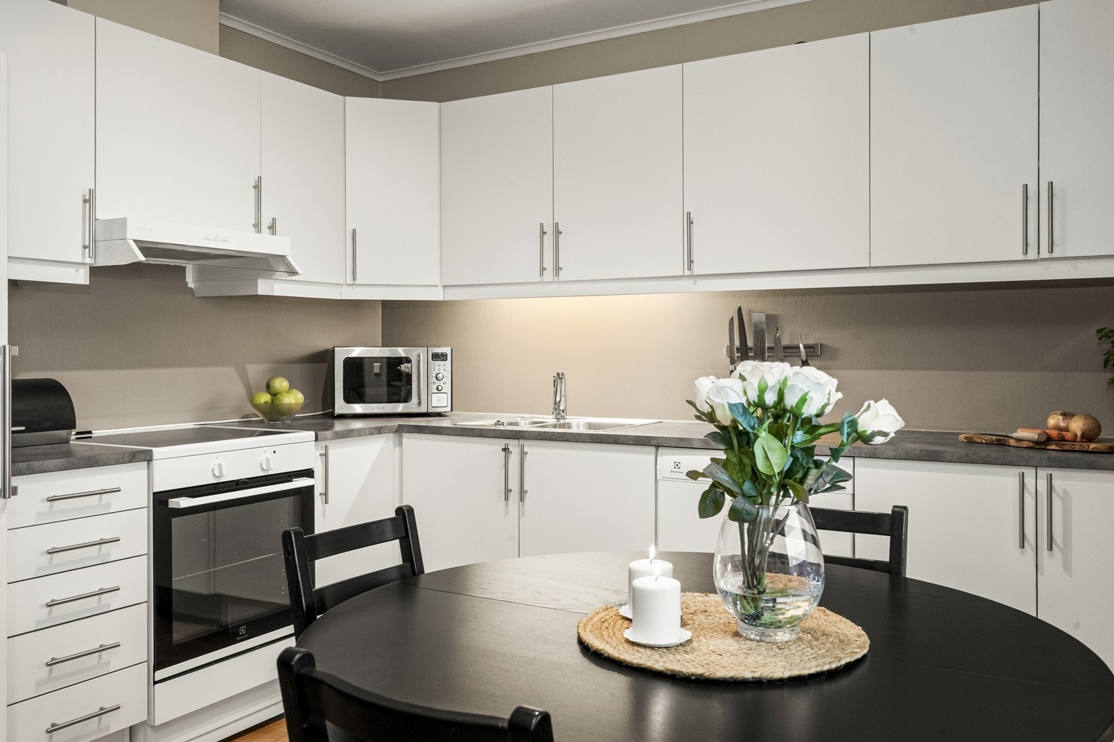 Hvite, glatte fronter og laminat benkeplate gir et tidløst uttrykk. Galleribilde