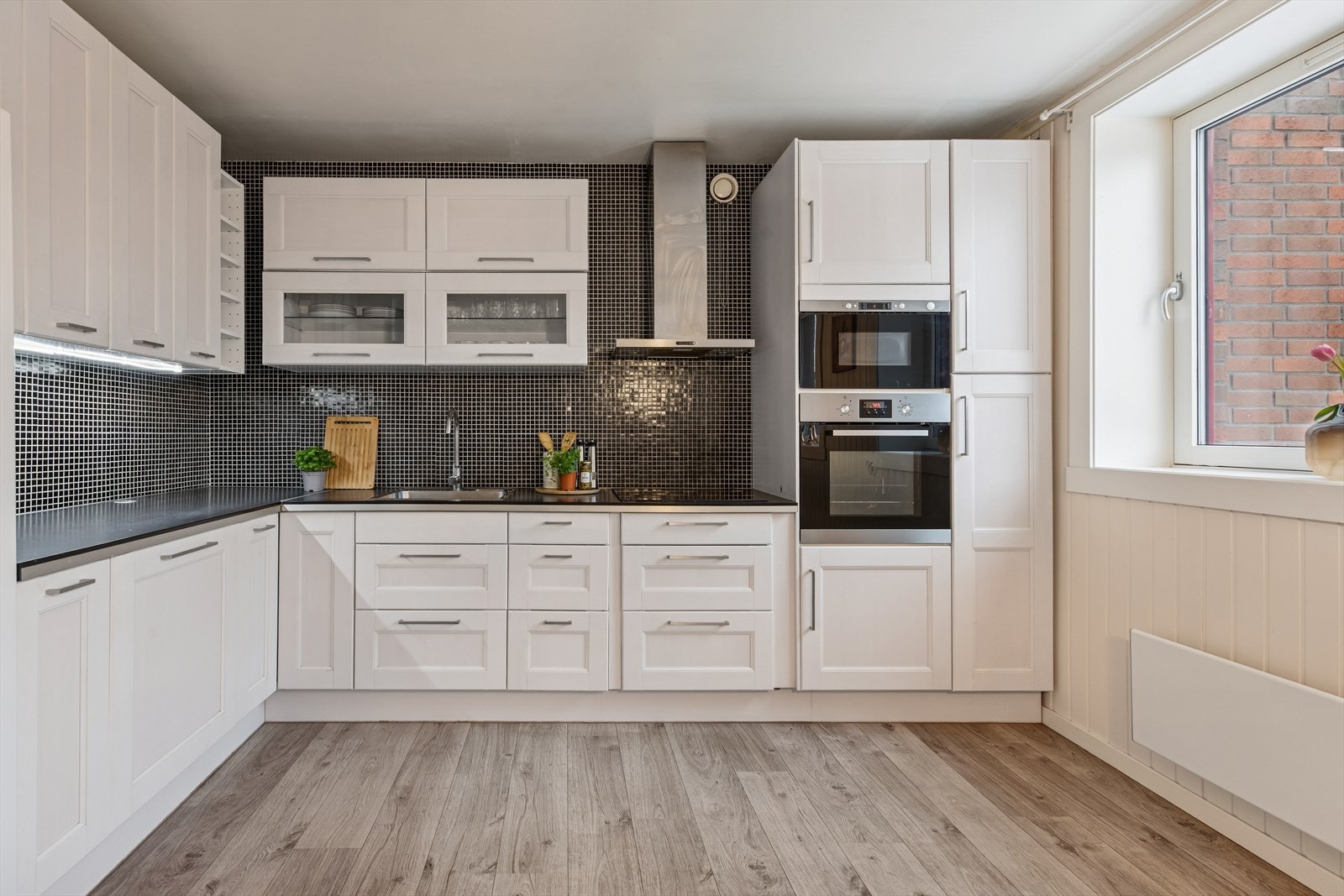 Profilerte fronter og laminat benkeplate gir et praktisk kjøkkenmiljø. Galleribilde