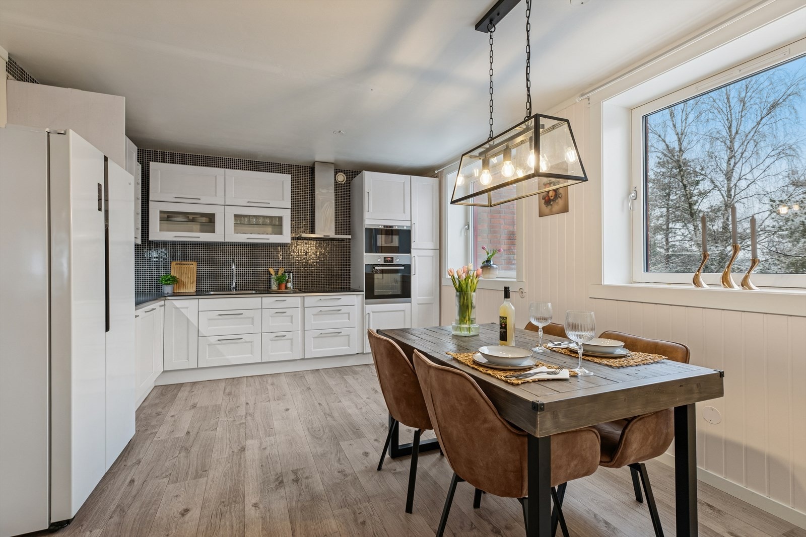 Spisebordet er plassert ved vinduet, som gir utsyn mot uteområdet. Galleribilde