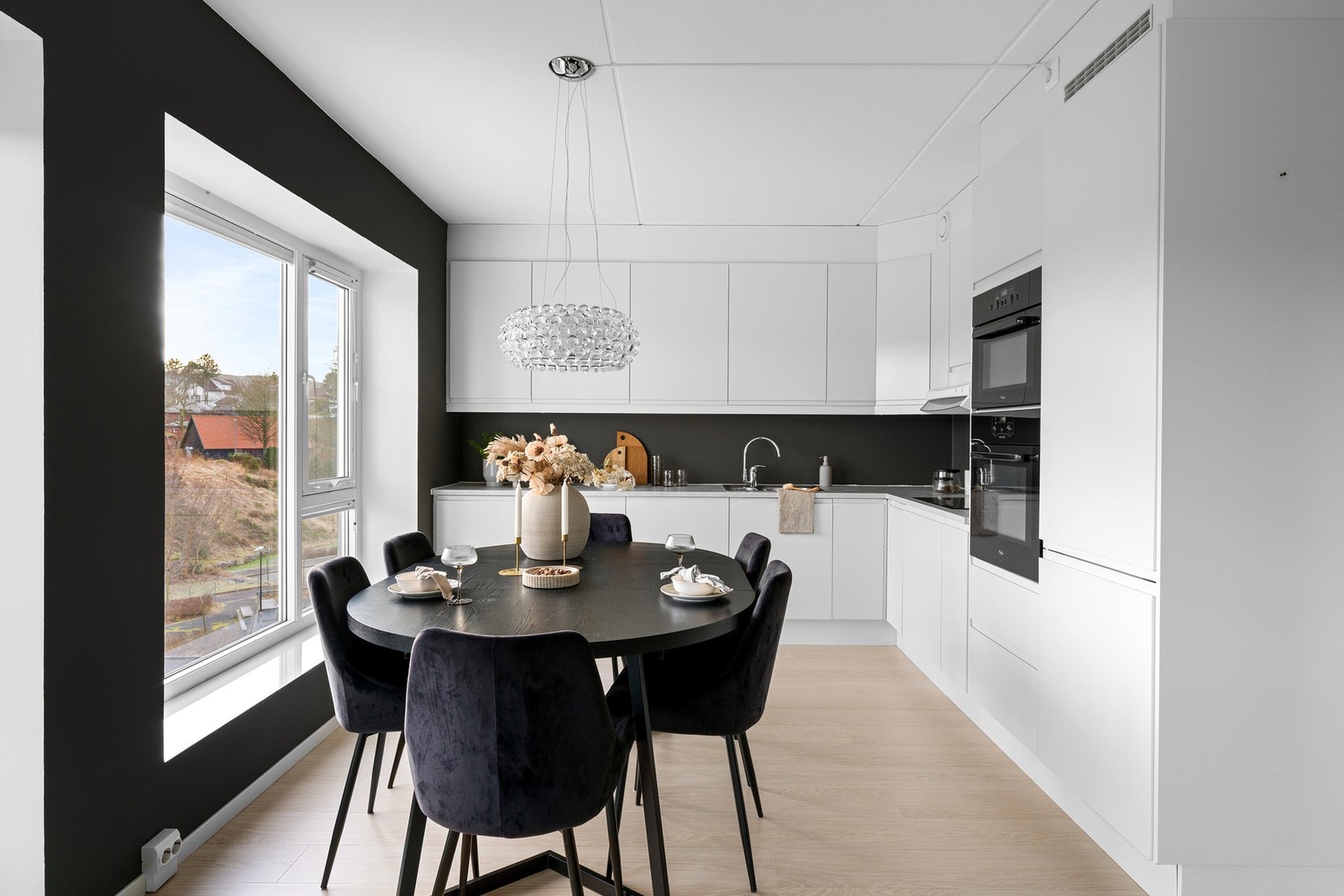 Kjøkkeninnredning med hvite slette fronter og benkeplate i laminat. Galleribilde