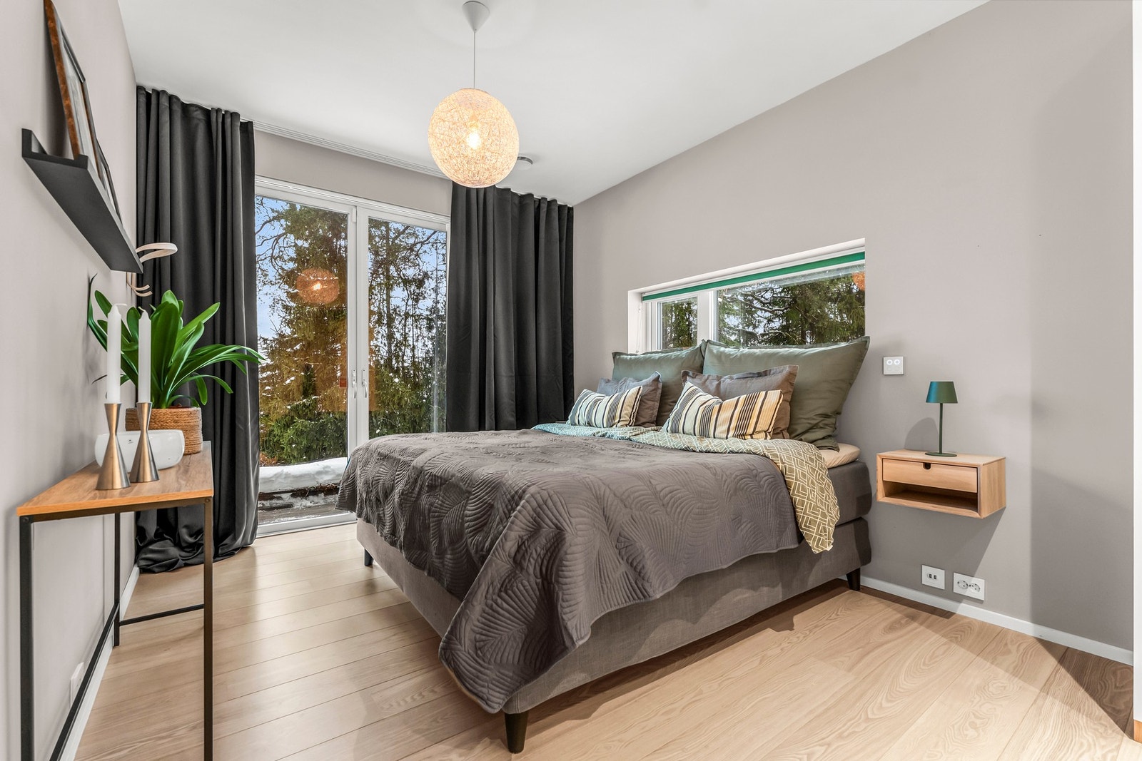 Lyst og moderne hovedsoverom med store vinduer som gir godt lysinnslipp og utsikt til naturen utenfor. Galleribilde