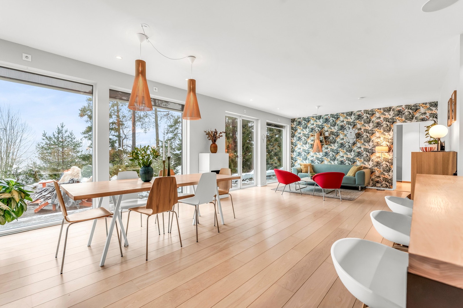 Lys og romslig stue med store vinduer, moderne belysning og gjennomgående utsikt over grøntarealene rundt Galleribilde