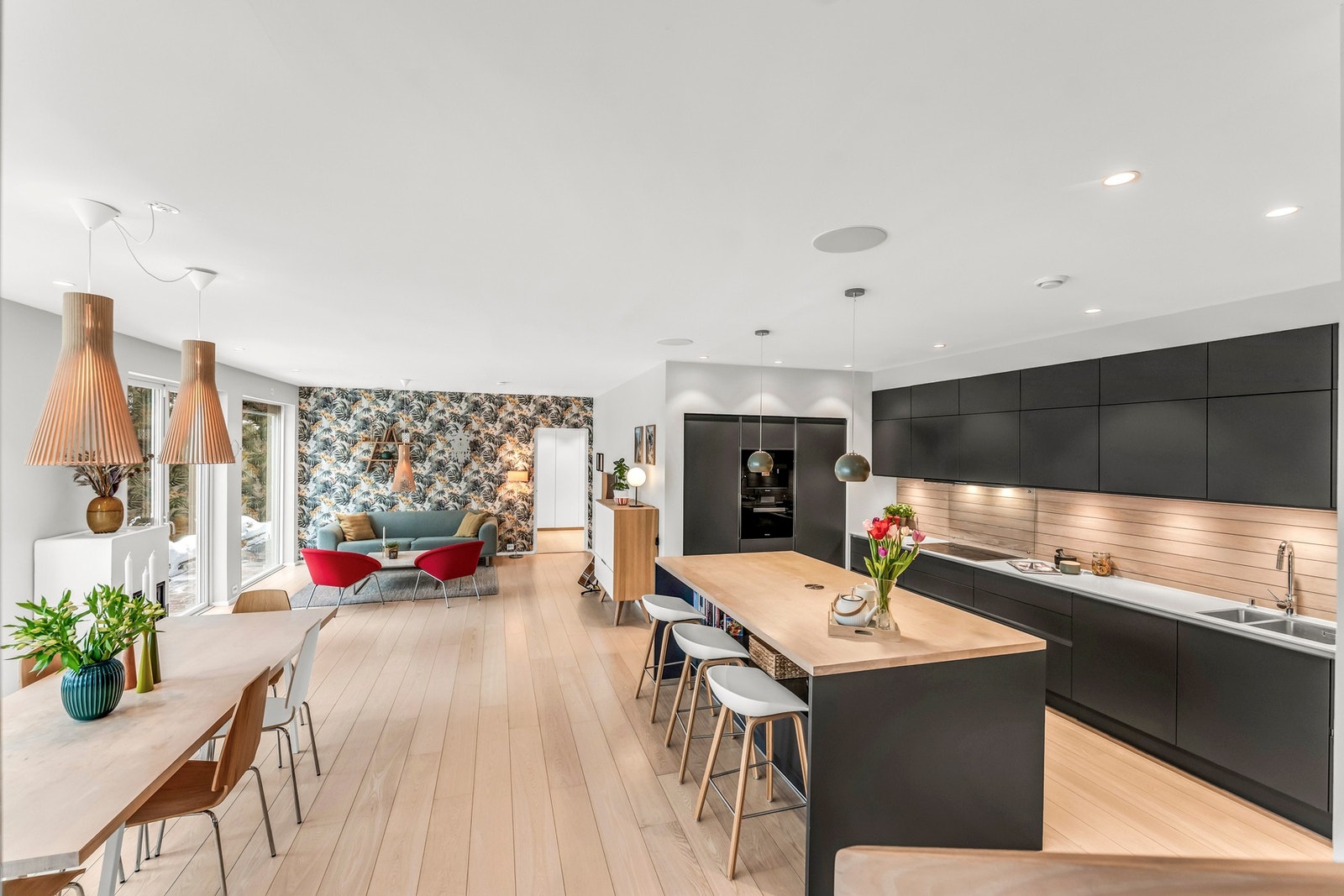 Åpen stue- og kjøkkenløsning med moderne design og god belysning. Lun 1-stavsparkett og store vinduer gir mye naturlig lys. Galleribilde