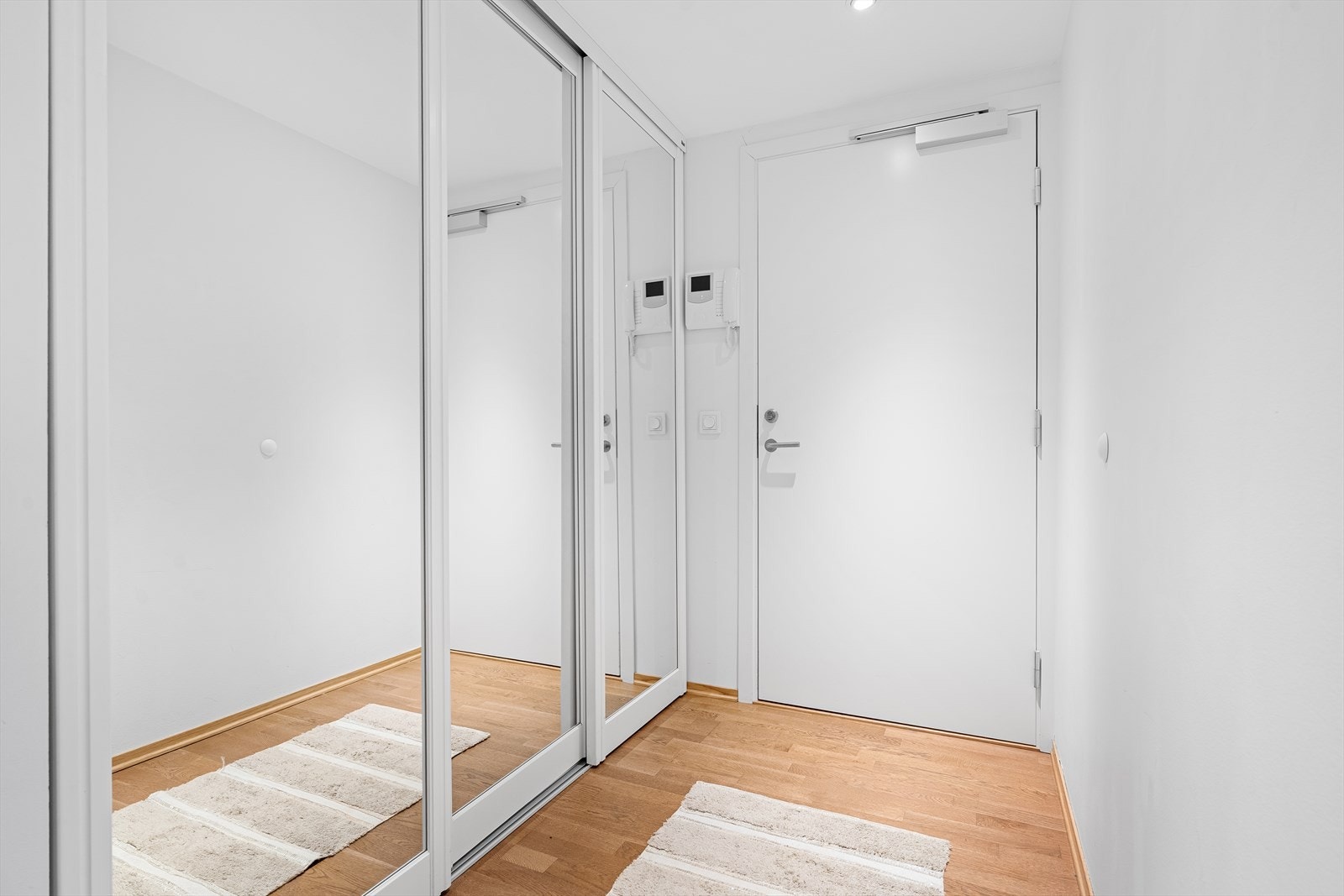 I entreen er det en skyvedøresgarderobe med speilfronter som gir gode oppbevaringsmuligheter. Porttelefon med kamera slipper venner og familie enkelt inn i bygget. Galleribilde