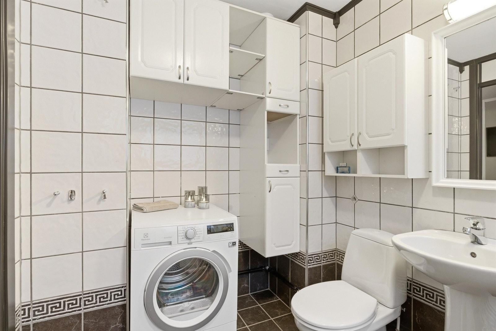 Flott flislagt bad som er modernisert i 2018 - Servant, toalett, dusjvegger/hjørne og opplegg for vaskemaskin. Galleribilde